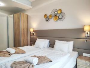 1 dormitorio con 2 camas y toallas. en Spa Residence Carbona Siesta Apartman en Hévíz