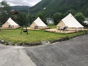 a group of tents with tables and chairs in the grass at Skysstasjonen Cottages in Røldal
