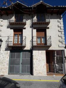 a building with doors and balconies on a street at Arcalís in Rascafría