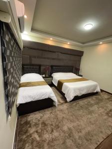two beds in a hotel room with two bedsvisor at Oqdeh studio in Jerash