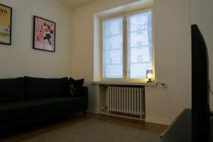 a living room with a couch and a window at Kompakti Asunto Helsingin Sydämessä in Helsinki