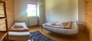 a small room with two beds and a window at Domek wiejski in Dwernik