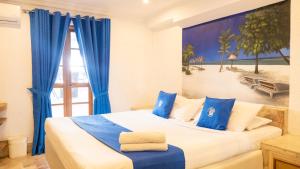 um quarto com uma cama grande e cortinas azuis em Clarkton Hotel Apartment em Angeles