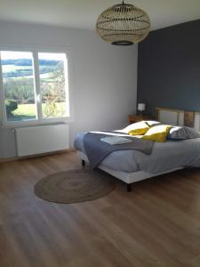 1 dormitorio con cama y ventana grande en Agréable chambre meublée, vue sur la vallée de l'Auxois en Villy-en-Auxois