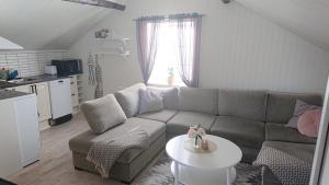 a living room with a couch and a table at Myntloftet med inglasad bubbelbad in Borlänge