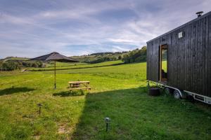 a tent and a picnic table in a field at Off-grid, Eco Tiny Home Nestled In Nature in Alton Pancras