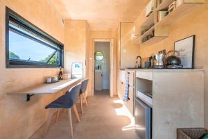 a small kitchen in a tiny home with a counter and a window at Off-grid, Eco Tiny Home Nestled In Nature in Alton Pancras