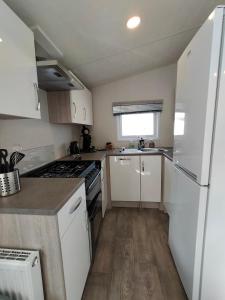 Cucina o angolo cottura di BJ Chalets - De Rug 1 - Vakantiepark Lauwersoog - LUXE chalet met vaatwasser! Vroege incheck!