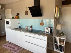 a kitchen with a counter with a sink and a microwave at Sea Views Penthouse in Sitges