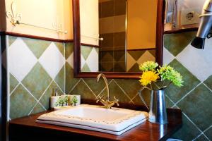 a bathroom with a sink and a vase with flowers at El Valle de la Mantequilla in Aldehuela del Rincón +16 photos