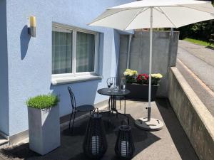 a table with an umbrella next to a building at Wonderful & Private Room with en-suite bathroom in Triesenberg