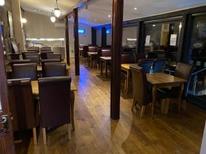 une salle à manger avec des tables et des chaises en bois dans l'établissement Grapes Hotel, Bar & Restaurant Snowdonia Nr Zip World, à Blaenau Ffestiniog