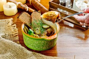 a person eating a bowl of soup with a spoon at Hotel Polina in Saratov