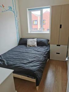 a small bed in a room with a window at Entire 3 bedroom house Manchester free parking in Manchester