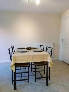a dining room table with chairs and a table cloth at Entire 3 bedroom house Manchester free parking in Manchester