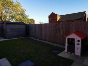 a backyard with a fence and a dog house at Entire 3 bedroom house Manchester free parking in Manchester