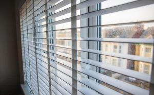 a window with blinds looking out at a building at Withnell Stays - Apartment Three - Retro Gaming in Blackpool