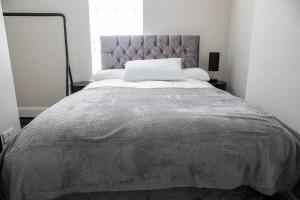um quarto com uma cama grande e um edredão branco em Withnell Stays - Apartment Three em Blackpool