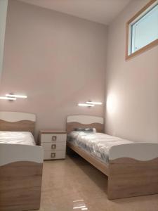 Un dormitorio con dos camas y una ventana. en SCENU', en Martina Franca