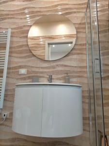 Un baño con un lavabo blanco y un espejo. en SCENU', en Martina Franca 6 fotos más