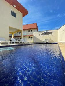 a swimming pool in front of a house at Residencial 220 Maresias in Maresias