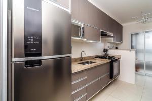 une cuisine avec un réfrigérateur en acier inoxydable dans l'établissement Piemax Praia Grande - 100m PRAIA do BOQUEIRÃO e CENTRO - Vista MAR - Varanda GOURMET com CHURRASQUEIRA privativa - AR CONDICIONADO em todos os ambientes - Wi-Fi 600 Mbps - HOME OFFICE- Vaga de Garagem - Acomoda até 6 pessoas, à Praia Grande 37 autres photos