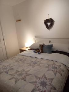 a bedroom with a bed with a heart hanging on the wall at Charming lodge cosy comfortable ideal location in Blairgowrie