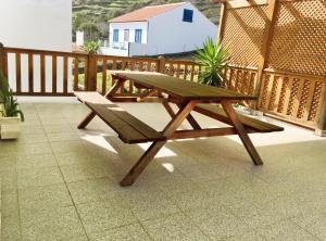 a wooden picnic table and bench on a balcony at Alo Baía São Lourenço in Santa Bárbara