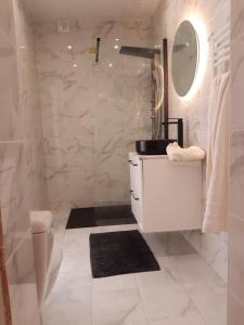 a white bathroom with a sink and a mirror at T2 tout confort, GP / Moto / 24h / Le Mans Classic in Le Mans
