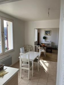 a kitchen and dining room with a table and chairs at appartement spacieux et lumineux proche de la plage in Quimiac