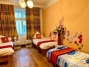 una camera con due letti e un vaso di fiori di Blue Rose Apartman a Karlovy Vary