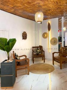 um quarto com cadeiras, uma mesa e um vaso de plantas em Alebahli Hostel Ilhabela ᵇʸ ᴬᴸᴱᴮᴬᴴᴸᴵ em Ilhabela