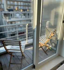 una silla sentada en un balcón junto a una ventana en Crèmebol en Nieuwpoort