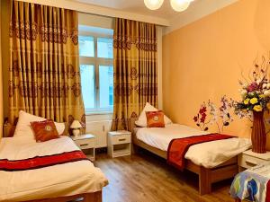 Cette chambre comprend 2 lits et une fenêtre. dans l'établissement Blue Rose Apartman, à Karlovy Vary