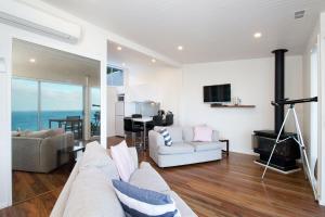 a living room filled with furniture and a tv at Seafarers Getaway in Apollo Bay
