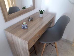 a wooden desk with a chair and a mirror at POLITIS STUDIOS in Kefalos