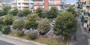 een rij bomen op een parkeerplaats voor een gebouw bij Al Pepe Rosa di Borghetto in Borghetto Santo Spirito
