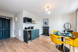 kuchnia i jadalnia ze stołem i żółtymi krzesłami w obiekcie One Capel Suites w Dublinie