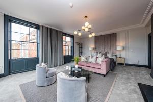 duży salon z różową kanapą i krzesłami w obiekcie One Capel Suites w Dublinie