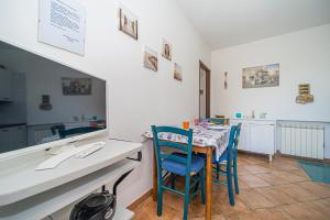 uma sala de jantar com uma mesa e cadeiras azuis em Appartamento villa da 4 fino a 5 persone giardino em Capoliveri