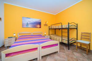 um quarto com 2 beliches e uma parede amarela em Appartamento villa da 4 fino a 5 persone giardino em Capoliveri
