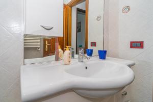 uma casa de banho com um lavatório branco e um espelho. em Appartamento villa da 4 fino a 5 persone giardino em Capoliveri