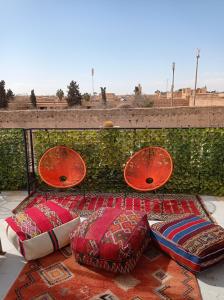Stork Marrakech Luxury Hostel في مراكش: مجموعة من الوسائد والمظلات على الفناء