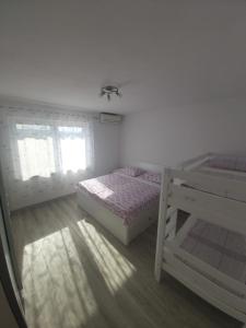 a bedroom with two bunk beds and a window at Apartman Maslov in Duće