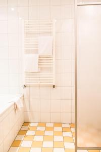 a bathroom with a shower with white tiles at Hotel Bakker in Vorden