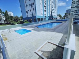 uma piscina ao lado de um edifício em Apartamento de un dormitorio en Edificio "Luna de Mar" em Punta del Este