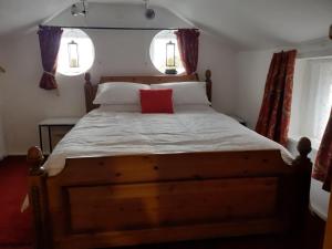 a bedroom with a wooden bed with a red pillow at Seaview Cottage 24 Freeman Street in Wells next the Sea