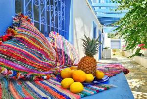 a plate of oranges and a pineapple on a blanket at Pleiades Alinda Bay Leros in Alinda