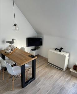 ein Esszimmer mit einem Tisch, einem TV und einem Schreibtisch in der Unterkunft Crèmebol in Nieuwpoort