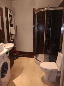 a bathroom with a shower and a toilet and a sink at Apartament Marzenie 10 - Opole in Opole